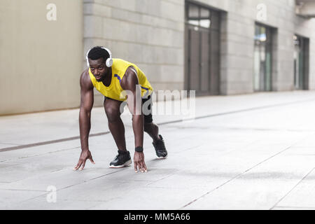 L'uomo africano in esecuzione di avviare pongono sulla strada della citta'. Colpo all'aperto, la mattina. Primavera o estate Foto Stock