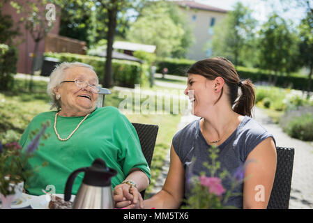 Senior donna divertendosi con un infermiere Foto Stock