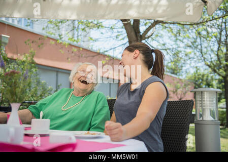 Senior donna ridere con infermiera presso la casa di cura Foto Stock