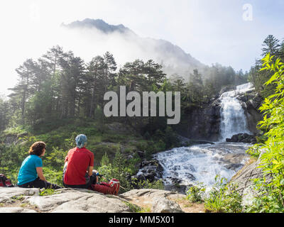 Gli escursionisti ammirando vista panoramica delle cascate del Gave de Gaube river, Francia Foto Stock