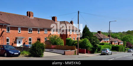 All'inizio degli anni novanta in mattoni rossi a due piani a breve case Terrazza a Mare Mills, Bristol Garden borgo con un parcheggio fuori strada Foto Stock