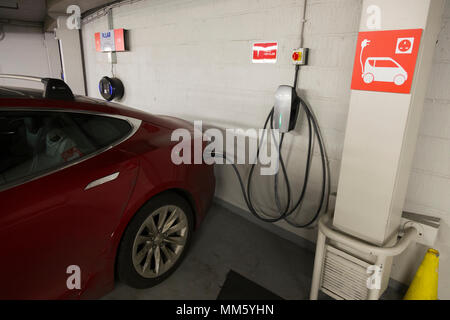 Tesla auto elettrica la carica dentro la metropolitana multipiano / livello parco auto gestito da Q Park di Cavendish Square. Londra. W1G 0PN. Regno Unito. (96) Foto Stock