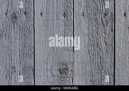 Un primo piano di una parte esterna di una parete in legno con alcune linee orizzontali e screpolata vernice vecchia. Foto Stock