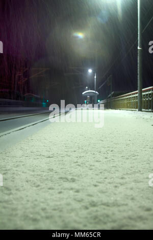 Notte perron. Nevicata sulla deserta stazione ferroviaria, umore di abbandono e di imprevedibilità (Solitudine). Pericolo per la ricezione di Hollywood film di criminalità Foto Stock