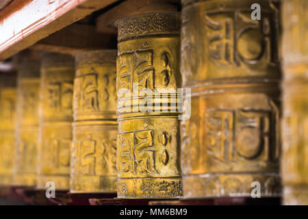 Buddista Tibetana pregando ruote in Ladakh, India. Tradizionalmente il mantra Om mani padme Hum è scritto in sanscrito sulla parte esterna della ruota Foto Stock