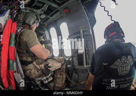 Pararescuemen guardare fuori alla vista da sopra l'acqua sul loro modo di san Tommaso. Avieri dal New York Air National Guard la 106ª Ala di soccorso vola su san Tommaso e San Giovanni in un HH-60 Pave Hawk elicottero il 10 settembre, 2017. Essi sono alla ricerca di persone in stato di bisogno di assistenza critica dopo il passaggio dell uragano Irma. Foto Stock