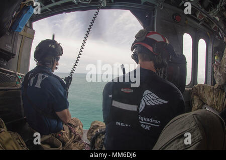 Pararescuemen guardare fuori alla vista da sopra l'acqua sul loro modo di san Tommaso. Avieri dal New York Air National Guard la 106ª Ala di soccorso vola su san Tommaso e San Giovanni in un HH-60 Pave Hawk elicottero il 10 settembre, 2017. Essi sono alla ricerca di persone in stato di bisogno di assistenza critica dopo il passaggio dell uragano Irma. Foto Stock