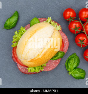 Baguette sandwich con salame prosciutto square da ardesia sopra vista superiore Foto Stock