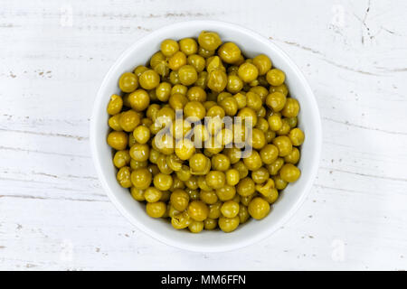 Piselli verdi da sopra ciotola di legno di legno della scheda Foto Stock