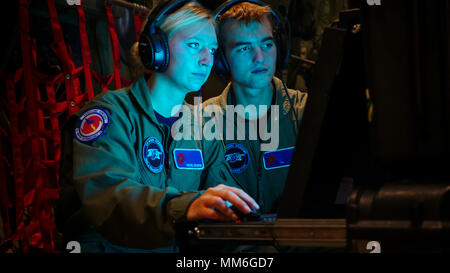 Il guardiamarina Rachel Boushon (sinistra) e il guardiamarina Casey Densmore (a destra), l'Accademia Navale di Annapolis, Annapolis, Maryland, analizzare i dati da una base navale acqua sensore di caduta è sceso attraverso il tubo su un WC-130J Super Hercules dalla Air Force Reserve Tech. Sgt. Karen Moore, loadmaster, 53rd Meteo squadrone di ricognizione, Keesler Air Force Base, Mississippi, durante una missione attraverso l'occhio dell'Uragano Irma sett. 10, 2017. La Air Force Reserve 53rd Meteo squadrone di ricognizione "Hurricane Hunters' fly WC-130J Super Hercules anche se l'occhio di uragani attivo per raccogliere dati meteo utilizzando aeromobili e extern Foto Stock