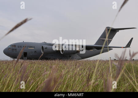 Big bluestem erba onde nel tardo pomeriggio brezza di fronte ad una C-17A dal 445th Airlift Wing, Wright-Patterson Air Force Base in Ohio, Air Force comando Reserve, a Tinker Air Force Base in Oklahoma, Sett. 12, 2017. Big bluestem è un'erba alta nativa per gran parte delle grandi pianure e le praterie regioni del centro America del Nord ed è l'erba primario utilizzato per controllo di erosione a Tinker AFB. (U.S. Air Force foto/Greg L. Davis) Foto Stock