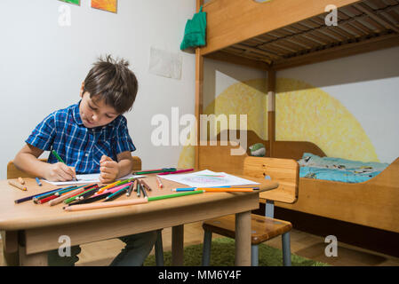 Ragazzo colorazione con matite colorate Monaco di Baviera, Germania Foto Stock