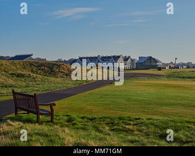 Da una panca in legno guardando oltre ai collegamenti House e il Carnoustie Golf Hotel intorno al primo tee e xviii verde. Carnoustie, Angus, Scozia. Foto Stock