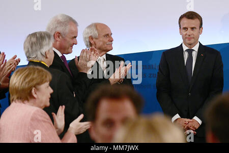 10 maggio 2018, Germania, Aachen: il presidente francese Emmanuel Macron in piedi accanto all'ex sindaco di Aachen dal Partito Social Democratico, Juergen Linden (2R) e il Cancelliere tedesco Angela Merkel (L, CDU). Il presidente francese che, per il suo servizio all unità europea sta ricevendo il Charlemgane internazionale premio. Foto: Ina Fassbender/dpa Credito: dpa picture alliance/Alamy Live News Foto Stock