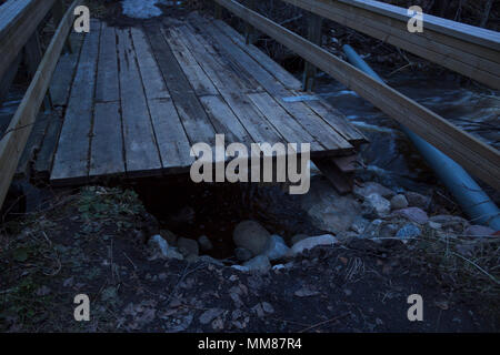 Ponte rotto da un diluvio di primavera di solito piccolo fiume in una foresta nel nord della Svezia. Foto Stock