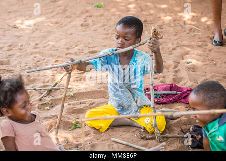 Giovani zambiani boy utilizza lamelle in legno per costruire con, villaggio Mukuni, Zambia Foto Stock