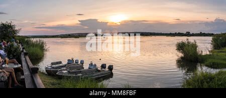 La vista dalla terrazza solarium della Royal Livingstone Hotel del Fiume Zambezi come il sole tramonta sull'acqua in Livingstone, Zambia Foto Stock