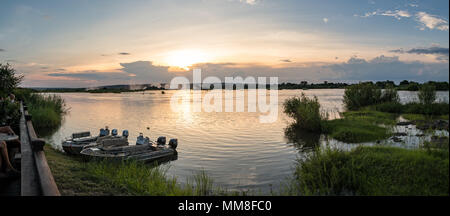 La vista dalla terrazza solarium della Royal Livingstone Hotel del Fiume Zambezi come il sole tramonta sull'acqua in Livingstone, Zambia Foto Stock