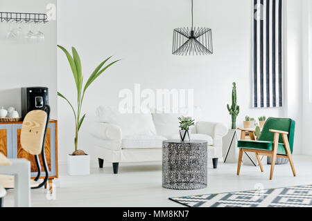 Interno multifunzionale con divano bianco, moquette, poltrona e houseplant Foto Stock