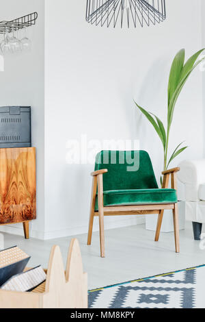 Confortevole poltrona verde in piedi in camera bianca Foto Stock
