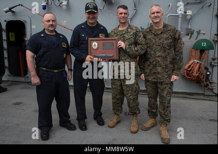 170915-N-RU971-172 Mare delle Filippine (sett. 15, 2017) da sinistra, il comando Master Chief Theron Fischer, il comando master chief di assalto anfibio nave USS Bonhomme Richard (LHD 6), Cap. Larry McCullen, comandante della Bonhomme Richard, Col. Tye Wallace, Comandante del trentunesimo Marine Expeditionary Unit (MEU), e Sgt. Il Mag. Jim Lanham, sergente maggiore del trentunesimo MEU, posano con una lapide commemorativa durante un "blu-verde" tutte le mani con la chiamata sul ponte di volo di Bonhomme Richard. Il trentunesimo MEU conclude il loro addio a bordo distribuzione Bonhomme Richard come la nave è programmato per attivare o Foto Stock