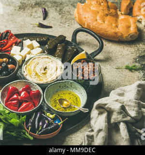 Mediterraneo e Medio Oriente starter meze platter. Farcite paprikas sottaceto, dolma, hummus, speziato olio, olive, pomodori secchi, noci, formaggio e f Foto Stock