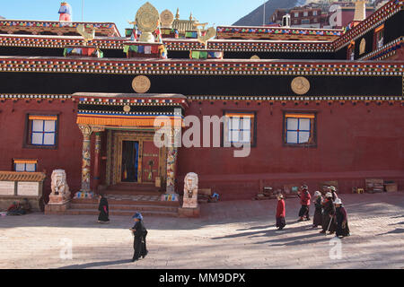 Il Tibetano pellegrini a piedi kora cerchi intorno al santo Bakong scrittura Stampa Monastero a Dege, Sichuan, in Cina Foto Stock