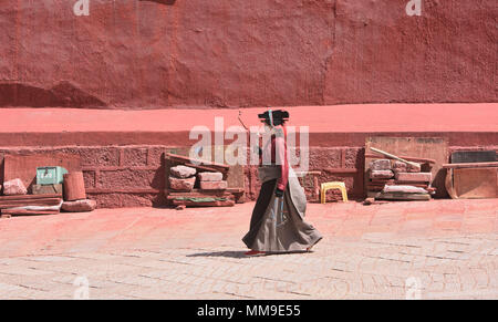 Pellegrino tibetano passeggiate kora cerchi intorno al santo Bakong scrittura Stampa Monastero a Dege, Sichuan, in Cina Foto Stock