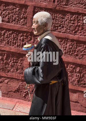 Pellegrino tibetano passeggiate kora cerchi intorno al santo Bakong scrittura Stampa Monastero a Dege, Sichuan, in Cina Foto Stock