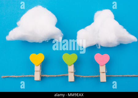 Colorato hearted di clip con nuvole su uno sfondo blu Foto Stock