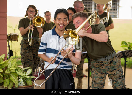 170919-N-OU129-348 LUMUT, Malaysia (19 settembre 2017) Sgt. Colin Deeter della III Marine Expeditionary Force (III) MEF brass band suona il trombone con un Royal Navy malese sailor durante un impegno nella comunità evento presso il Rumah Wawasan Manjung Raya orfanotrofio e casa di riposo di Lumut, Malaysia come parte della formazione marittima attività (MTA) Malaysia sett. 19, 2017. MTA Malaysia 2017 è una continuazione di 23 anni di impegni marittimi tra Stati Uniti La marina e la Royal Navy malese che serve a migliorare la capacità di reciproca nel garantire la sicurezza marittima e la stabilità. (U.S. Navy photo by Mas Foto Stock