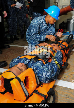 170921-N-PX867-056 SAN DIEGO (21 settembre 2017) Ospedale Corpsman 3rd Class Mitchell Harris, assegnato a Amphibious Assault nave USS Boxer (LHD 4), fissa le cinghie su un manicotto di Reeves durante un incidente di massa sulla punta del Boxer pasticcio ponti. Boxer è nella sua homeport subendo un phased-disponibilità di manutenzione. (U.S. Foto di Marina di Massa lo specialista di comunicazione di terza classe Justin Whitley/rilasciato) Foto Stock