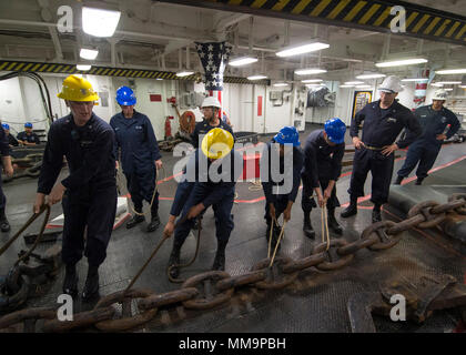 170921-N-OE873-1052 SAN DIEGO (sett. 21, 2017) velisti assegnati all'assalto anfibio nave USS Makin Island (LHD 8) spostare la dritta catena di ancoraggio durante una catena off-load nel castello di prua. Makin Island è attualmente in bacino di carenaggio di General Dynamics National la siderurgia e la costruzione navale Company (NASSCO) per un deposito di manutenzione di livello di disponibilità. (U.S. Foto di Marina di Massa lo specialista di comunicazione di terza classe Aser Allen) Foto Stock