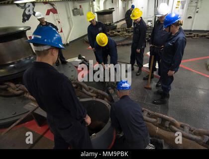 170921-N-OE873-1108 SAN DIEGO (sett. 21, 2017) velisti assegnati all'assalto anfibio nave USS Makin Island (LHD 8) fissare un pellicano morsetto per la dritta catena di ancoraggio durante una catena off-load nel castello di prua. Makin Island è attualmente in bacino di carenaggio di General Dynamics National la siderurgia e la costruzione navale Company (NASSCO) per un deposito di manutenzione di livello di disponibilità. (U.S. Foto di Marina di Massa lo specialista di comunicazione di terza classe Aser Allen) Foto Stock