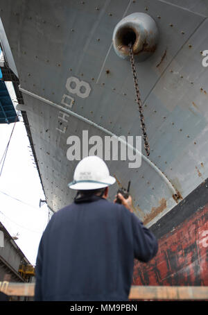 170921-N-LI768-1017 SAN DIEGO (sett. 21, 2017) Master Chief di Boatswain Mate Claus Moser comunica con i marinai nel castello di prua dell'assalto anfibio nave USS Makin Island (LHD 8) riducendo al contempo il carico di tribordo della catena di ancoraggio. Makin Island è attualmente in bacino di carenaggio di General Dynamics National la siderurgia e la costruzione navale Company (NASSCO) per un deposito di manutenzione di livello di disponibilità. (U.S. Foto di Marina di Massa lo specialista di comunicazione 2a classe Devin M. Langer) Foto Stock