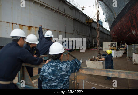 170921-N-LI768-1187 SAN DIEGO (sett. 21, 2017) velisti assegnati all'assalto anfibio nave USS Makin Island (LHD 8) osservare l'off-load di tribordo della catena di ancoraggio. Makin Island è attualmente in bacino di carenaggio di General Dynamics National la siderurgia e la costruzione navale Company (NASSCO) per un deposito di manutenzione di livello di disponibilità. (U.S. Foto di Marina di Massa lo specialista di comunicazione 2a classe Devin M. Langer) Foto Stock