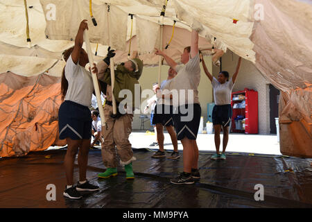 Membri della 81st Medical Group montare una tenda di decontaminazione durante la 81st MDG integrato in-place di decontaminazione del paziente corso di formazione dietro il Keesler Medical Center sett. 14, 2017, su Keesler Air Force Base, Mississippi. I due giorni del corso addestrato 21 personale, che provenivano da quattro diversi disaster squadre mediche: IPPD, di classificazione, di manodopera e di sicurezza. Durante il corso di formazione, hanno imparato a utilizzare Keesler fissi della stazione di decontaminazione e come impostare e abbattere la tenda di decontaminazione. (U.S. Air Force foto di Kemberly Groue) Foto Stock