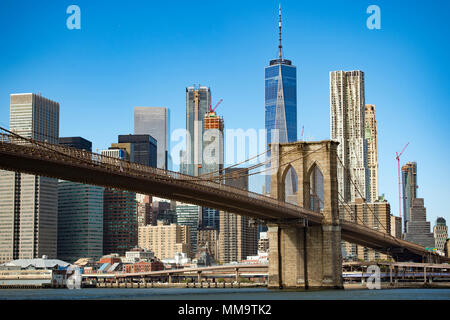 Skyline di Manhattan con il ponte di Brooklyn e la One World Trade Center in background durante una giornata di sole in New York, Stati Uniti d'America. Foto Stock