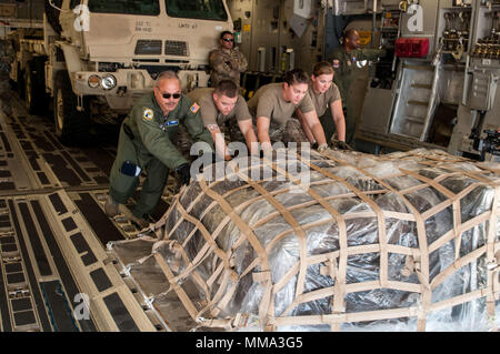 Stati Uniti I soldati dell esercito assegnato alla sede centrale e sede di distacco, 332Battaglione di trasporto, e DEGLI STATI UNITI Air Force aviatori di la 315Airlift Wing spingere un pallet carico di combattimento materiel al di fuori di un'U.S. Air Force C-17 Globemaster III piano di carico durante un'antenna ridistribuzione missione di formazione sett. 27, 2017, a MacDill Air Force Base, Fla. la simulazione del movimento di distribuzione era la parte culminante di una settimana di Deployment Readiness esercizio di livello III. Il DRE A LIVELLO III è un multi-dimensionale del mondo reale evento di formazione in cui una unità è notificata a mobilitare e deve essere preparata Foto Stock