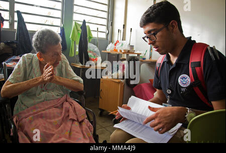 Vega Baja, PR, Settembre 27, 2017 - superstite Miguelina Olivo colloqui con Axel Ayala, assistenza individuale specialista, circa le sue precedenti esperienze con gli uragani. Un team di assistenza individuale specialisti&nbsp;visitato un rifugio situato presso il lino Padr&oacute;n di alta scuola per aiutare i sopravvissuti registrarsi con FEMA. Yuisa Rios/FEMA Foto Stock