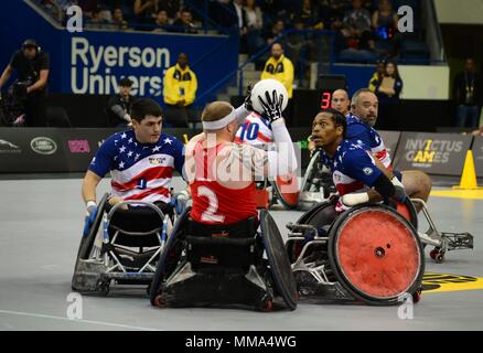 Stati Uniti Marine Corps Sgt. Ivan Sears (sinistra) e U.S. Marine Corps veterano Anthony McDaniel (a destra), i membri del team statunitense, sfida un giocatore avversario durante il Rugby in carrozzina finali all'2017 Invictus giochi in Mattamy Centro Atletico a Toronto, Canada, Sett. 28, 2017. La Invictus giochi sono stati stabiliti dal principe Harry del Galles nel 2014 e hanno riunito più di 550 feriti e veterani feriti a prendere parte a 12 adaptive eventi sportivi. (U.S. Air Force photo by Staff Sgt. Alexx Pons) Foto Stock