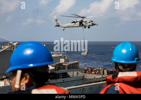 170928-N-AY374-134 MAR DEI CARAIBI (sett. 28, 2017) marinai a bordo dell'assalto anfibio nave USS Kearsarge (LHD 3) osservare come un MH-60 Sea Hawk trasferimenti in elicottero di pallet di forniture dal rapido supporto di combattimento nave USNS alimentazione (T-AOE 6) durante il rifornimento in mare per la continuazione delle operazioni in Puerto Rico. Kearsarge è assistere con i soccorsi dopo il passaggio dell uragano Maria. Il Dipartimento della difesa è di sostenere la Federal Emergency Management Agency, il piombo agenzia federale, per aiutare le persone colpite dall'uragano Maria per ridurre al minimo la sofferenza ed è un componente del complessivo Foto Stock