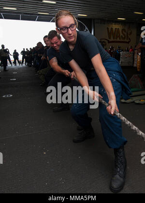 170926-N-BD308-0031 MAR DEI CARAIBI (sett. 26, 2017) velisti assegnati all'assalto anfibio nave USS Wasp (LHD 1) heave intorno a una linea in hangar bay durante un rifornimento in mare. Vespa è al largo dell'isola di Dominica fornendo aiuti per gli sfollati come parte della prima risposta sforzi nella scia di uragano Maria. Il Dipartimento della difesa è di sostenere gli Stati Uniti Agenzia per lo Sviluppo Internazionale (USAID), il piombo agenzia federale, per aiutare le persone colpite dall'uragano Maria per ridurre al minimo la sofferenza ed è un componente del complessivo intero-di-risposta del governo sforzo.(STATI UNITI Navy Foto Stock
