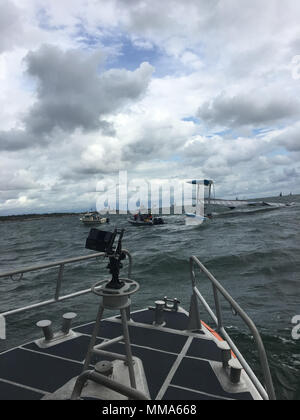 Stazione della Guardia costiera la Collina del Castello di 45 piedi risposta equipaggio barca arrivare sulla scena di un rovesciamento 32-piede catamarano con due persone in acqua e tre sulla nave off Jamestown, Rhode Island, sabato 7 settembre 30, 2017. L'equipaggio salvato i sopravvissuti, mettere il recipiente in stoppa e li portò tutti a Harbor olandese. (U.S. Coast Guard foto di Sottufficiali di 2a classe di Seth Pontecorvo) Foto Stock