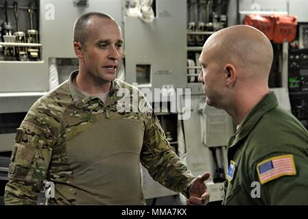 Il personale Sgt. Giacobbe Wright, 3d Airlift Squadron raggiungere 7170 loadmaster, parla con il Tech. Sgt. Jason Michel, 123contingenza Gruppo di risposta delle forze di sicurezza leader di squadra in una C-17 Globemaster III durante un uragano missione di rilievo a San Juan Luis Muñoz Marín Aeroporto di San Juan, Puerto Rico, a sett. 30, 2017. Raggiungere 7170 consegnato 118 mila libbre di pasti pronti da mangiare e acqua in bottiglia per essere distribuito in tutta l'devastato Puerto Rico con l aiuto di aviatori da 123contingenza Gruppo di risposta. (U.S. Air Force foto di Tech. Sgt. Matt Davis) Foto Stock