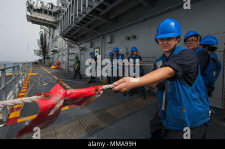 170926-N-BD308-0299 Mar dei Caraibi (sett. 26, 2017) velisti assegnati all'assalto anfibio nave USS Wasp (LHD 1) heave intorno a una linea durante un rifornimento in mare con il combattimento veloce nave appoggio USNS alimentazione (T-AOE-6). Vespa è al largo dell'isola di Dominica fornendo aiuti per gli sfollati come parte della prima risposta sforzi nella scia di uragano Maria. (U.S. Foto di Marina di Massa lo specialista di comunicazione di terza classe Levingston Lewis/rilasciato) Foto Stock