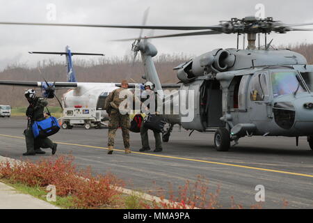 U.S Marine Il Mag. Robert Gill, dell'ufficiale responsabile della Joint Task Force - Sottovento isola l'elemento di sicurezza, aiuta i marinai degli Stati Uniti con un elicottero di combattimento di mare Squadron 22 allo scarico dei bagagli da un U.S. Navy SH-60 Seahawk elicottero a Douglas-Charles Aeroporto di Melville Hall, Dominica, Sett. 25, 2017. Gill e il suo Marines garantiscono la sicurezza e la stabilità in corrispondenza di zone di sbarco e presso l'U.S. Il dipartimento di stato di evacuazione del centro di controllo in aeroporto. Su richiesta dei paesi partner e il Dipartimento di Stato e gli Stati Uniti Agenzia per lo Sviluppo Internazionale, JTF-li ha distribuito degli aeromobili e servic Foto Stock