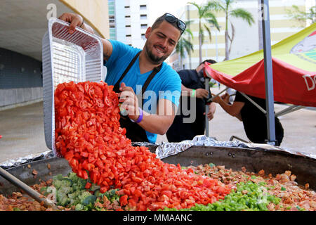 Alejandro Torres, uno chef volontariato con una organizzazione non-profit World cucina centrale, prepara un piatto per i residenti a José Miguel Agrelot Coliseum in San Juan, Puerto Rico, Ottobre 3, 2017. WCK preparati per alimentare circa 46.000 residenti. Lo Chef Jose Andres, il fondatore di WCK, supportato la Federal Emergency Management Agency aiutando coloro che sono colpiti dall uragano Maria per ridurre al minimo la sofferenza come parte del complessivo intero-di-risposta del governo sforzi. (U.S. Esercito foto di Pvt. Alleea Oliver) Foto Stock