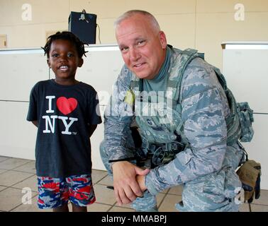 Master Chief Sgt. Joel Dauer, una delle forze di sicurezza manager entro il Washington Air National Guard scatta una fotografia con un bambino che partì l'isola di St Croix per continente Stati Uniti il 1 ottobre. I bambini con le scuole pesantemente danneggiate o distrutte dall uragano Maria continua a lasciare le Isole Vergini. Foto Stock