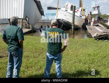 Texas Generale Ufficio di terra ai soccorritori di Gray Powell, sinistra e Jesse Mayorga sorvegliare il recupero di un relitto cabinato da Laredo la costruzione in Dickinson Bayou il 4 ottobre, 2017. La Guardia Costiera e TGLO stanno lavorando con gli altri enti federali, statali e agenzie tribali per coordinare gli sforzi di recupero dopo il passaggio dell uragano Harvey. Stati Uniti Coast Guard foto di Chief Petty Officer John Masson. Foto Stock